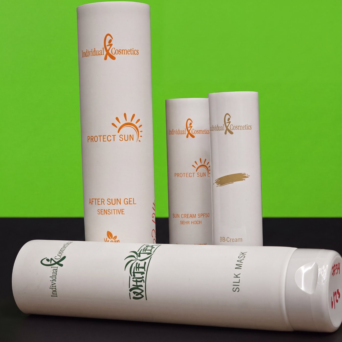 Mehrere weiße Kosmetiktuben mit orangefarbenem und weißem Siebdruck