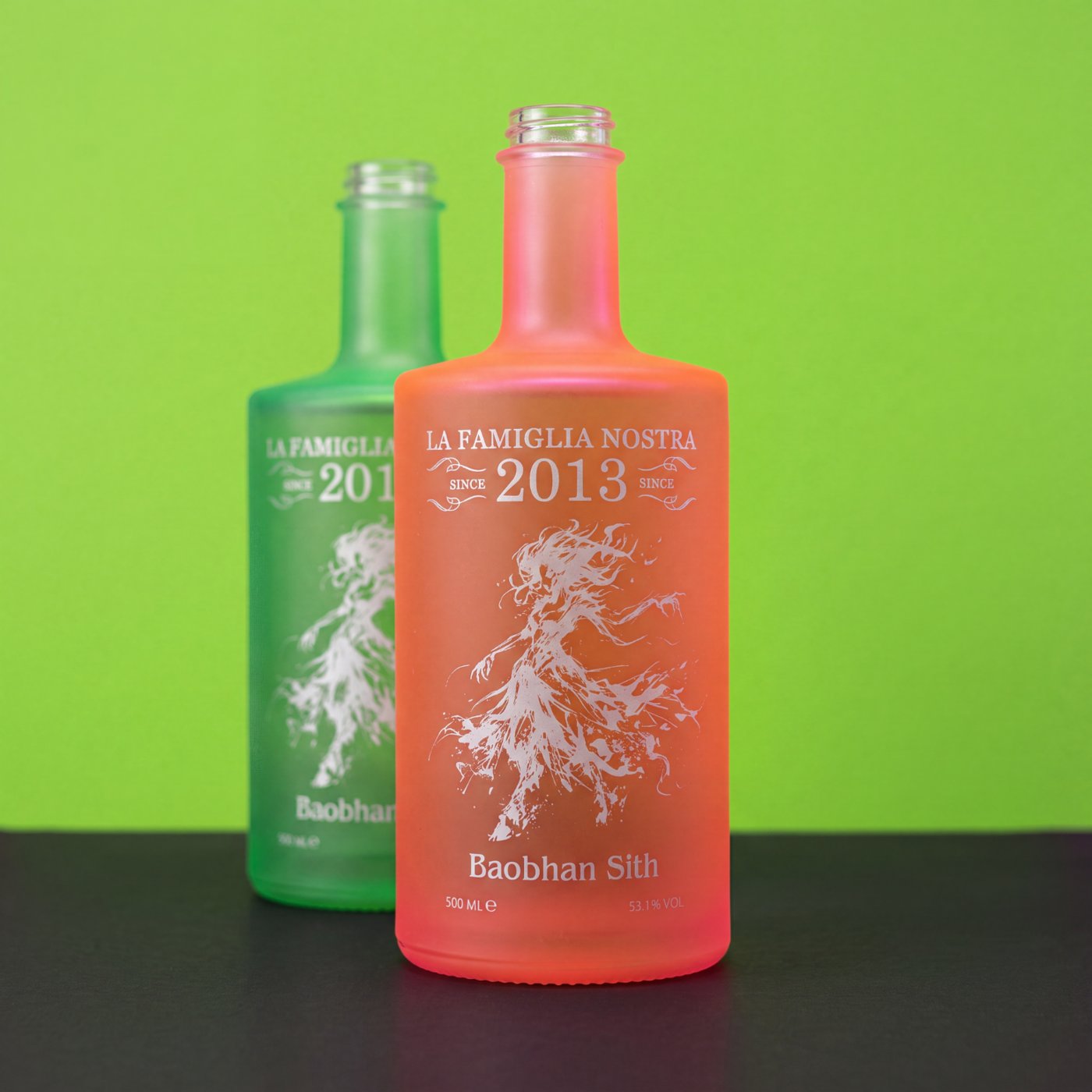 Grün und orange lackierte Glasflaschen mit weißem Siebdruck-Motiv